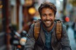 © DKPhoto - A young man with a bright smile wearing a backpack and casual attire, standing on a lively street with blurred urban background, conveying a sense of adventure and joy.