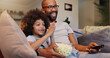 © WesSide/peopleimages.com - Father, boy and smile with television or popcorn on sofa in living room for movies, cartoon and entertainment. People, parent and happy with kid at home for streaming platform with child development