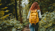 © Anastasiia Trembach - Girl tourist wearing a yellow backpack, rear view