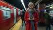 © Carmen - Portrait of young woman using smartphone and standing on subway station platform, passengers and trains in background