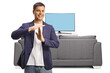 © Ljupco Smokovski - Young man gesturing time out in front of tv and sofa