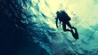 © Rattanathip - Silhouette of a scuba diver exploring the underwater world with rays of light filtering through the water's surface, deep ocean adventure.