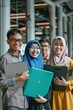 © cff999 - four young people in hijab holding laptops