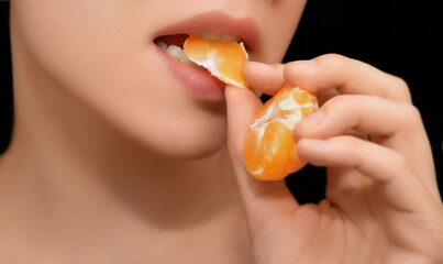 Woman Eating an Orange Slice. Close-up of a woman about to eat a slice of orange against a black background.