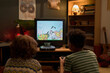 © pressmaster - Back view of two multiethnic boys sitting in front of old-fashioned TV in living room