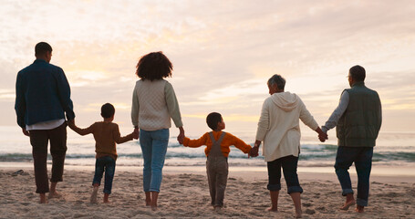 Canvas Print - Family, holiday and holding hands at beach in summer for relax, travel and vacation as silhouette. People, children and back at ocean with solidarity for walking, trust and love together by sunset