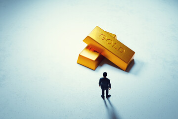 Man contemplating large gold bars on white surface