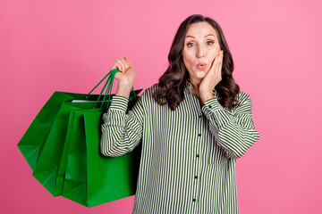 Poster - Photo of nice aged woman shop bags wear striped shirt isolated on pink color background