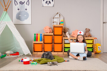 Sticker - Cute little girl with British cat, laptop and first aid kit at home