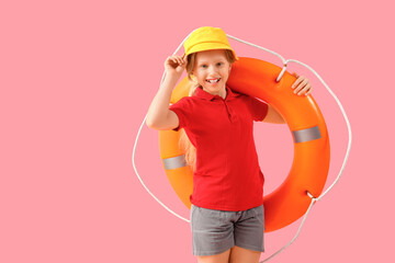 happy little girl lifeguard in summer hat with ring buoy on pink background