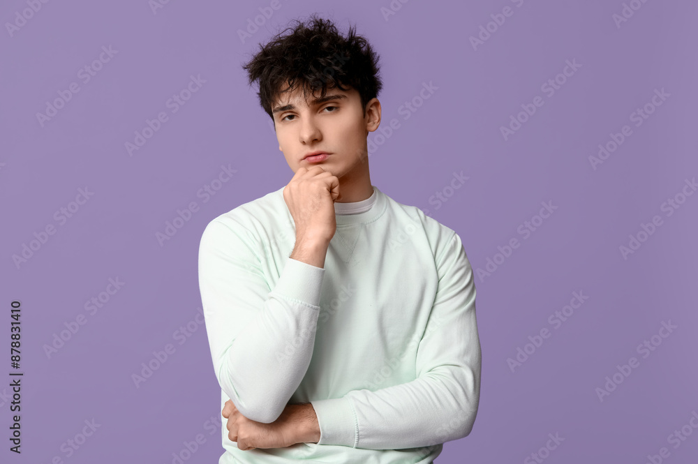 Handsome young man in stylish white sweatshirt on purple background