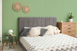 © Pixel-Shot - Modern bedroom with bed, wooden chest of drawers, bedside table and houseplant