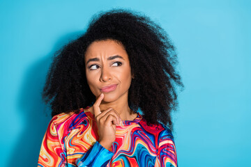 Wall Mural - Photo portrait of beautiful curly hair woman touch chin wearing trendy sweatshirt doubts about it isolated on blue color background