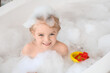 © Pixel-Shot - Cute little girl taking bath with foam and toys taking bath in bathroom