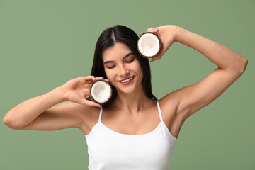 Wall Mural - Beautiful young woman with coconut on green background. Cosmetology concept