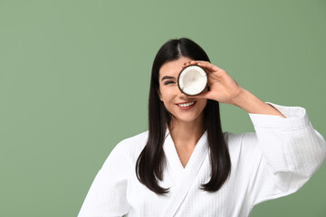 Wall Mural - Beautiful young woman with coconut on green background. Hair treatment