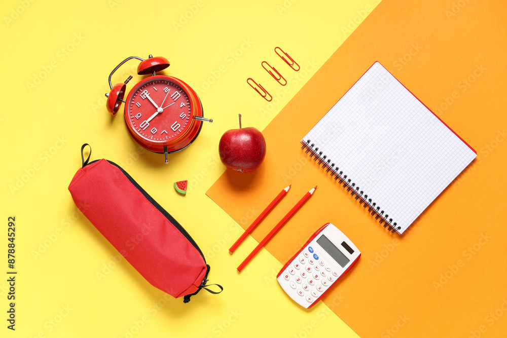 Alarm clock, tasty apple and different school stationery on color background
