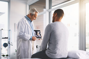 Doctor, man and patient with tablet for xray consultation of spine anatomy, inflammation and surgery planning. Senior radiologist, digital app and happy with health assessment and medical analysis