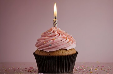 A pink cupcake with a lit candle on top