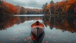 © jaykoppelman - A single canoe sits on a calm lake surrounded by autumn trees with vibrant foliage reflecting on the water creating a serene and peaceful setting