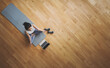 © Monster Ztudio - High angle view of young Asian woman practicing yoga and meditation at home sitting on floor in living room in lotus position with laptop and dumbbell. Mindful meditation and wellbeing concept