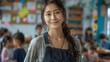© btiger - asian female teacher smiling in vibrant classroom with children playing and working casual attire standing hands on hips early thirties