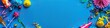 © awais - A vibrant blue background with colorful party decorations, top view and space for your message.