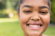 © Wavebreak Media - Close-up of a teenage biracial girl smiling outdoors, with copy space unaltered