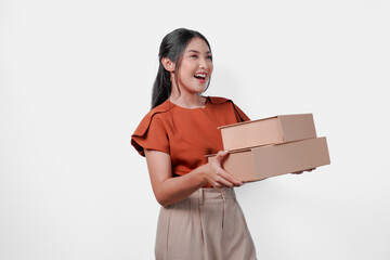 Wall Mural - Happy young Asian woman is holding two boxes and smiling, looking to the copy space aside.