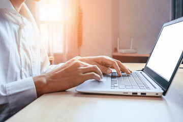 Wall Mural - businessman hand typing on computer keyboard of a laptop computer in office. business and finance co