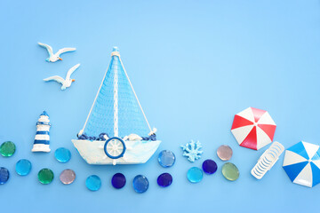 Wall Mural - Top view image of boat, sea glass and seagull birds over blue background