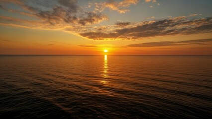 Canvas Print -  Sunset over the ocean casting a warm glow on the horizon