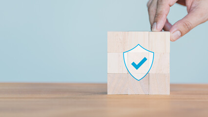 Poster - Hand put a wooden cube block with identity proof icon for security protection system on wood table. Certified guarantee approval or secure access system concept. Quality assurance of business service.