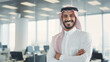 © Beshr - A businessman with arab features smiling and standing at the office