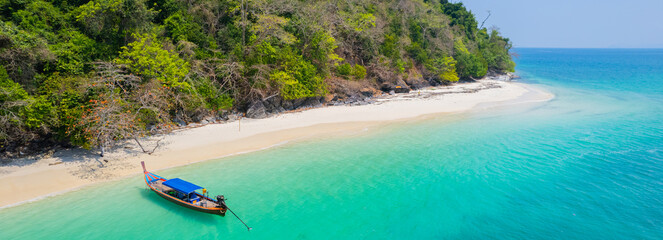 Wall Mural - Beautiful sandy beach with blue water and long tail boats on the beach in southern Thailand, Asia