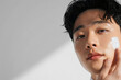© SOLDATOOFF - Young Korean man applying skincare cream, maintaining his beauty routine
