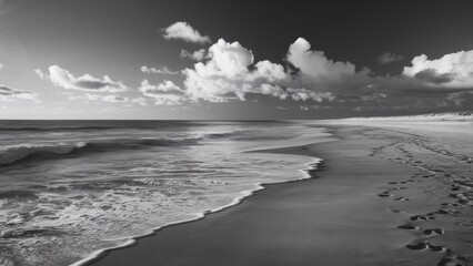 Wall Mural - A black and white photo of a beach with footprints in the sand, AI