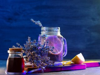 Wall Mural - lavender cocktail with lemon on a blue background. natural lavender syrup