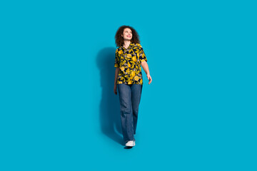 Sticker - Full length photo of adorable lovely girl wear print shirt walking looking empty space isolated blue color background