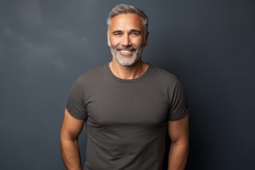 Wall Mural - Portrait of a joyful man in his 50s sporting a vintage band t-shirt on minimalist or empty room background