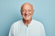 © Markus Schröder - Portrait of a grinning man in his 70s wearing a simple cotton shirt isolated in minimalist or empty room background