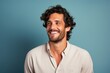 © Markus Schröder - Portrait of a happy man in his 30s wearing a simple cotton shirt while standing against solid color backdrop