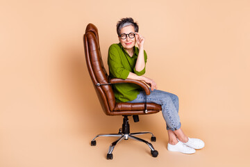 Canvas Print - Full size photo of pretty senior female entrerpreneur sit armchair wear trendy green outfit isolated on beige color background