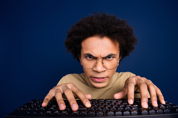 Photo portrait of handsome young man typing keyboard angry dressed stylish beige garment isolated on dark blue color background