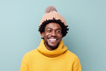 Sticker - Portrait of a happy afro-american man in his 30s dressed in a warm ski hat on solid pastel color wall