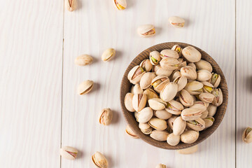 Wall Mural - Organic roasted pistachio nuts in a wooden bowl. Top view. 