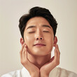 © SOLDATOOFF - A Korean man in his 30s enjoying a facial massage, with a serene expression and closed eyes