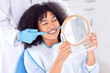 © Alex Shared/peopleimages.com - Woman, patient and dentist with mirror for teeth whitening in clinic for dental surgery and results with doctor. People, satisfied and happy on consultation for root canal procedure and oral care