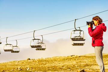 Poster - Woman with camera in mountains take travel photo