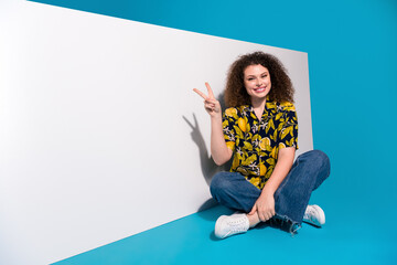 Wall Mural - Photo of charming nice girl stylish print clothes horizontal sale poster v-sign empty space isolated on blue color background